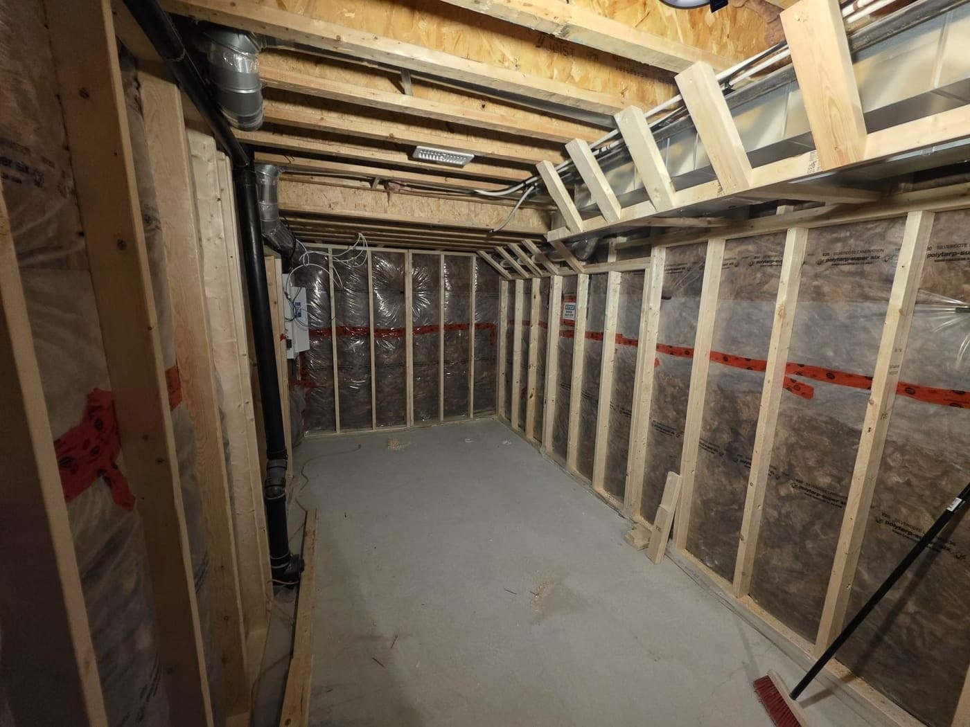 Basement framing with insulation and vapour barrier, before drywall