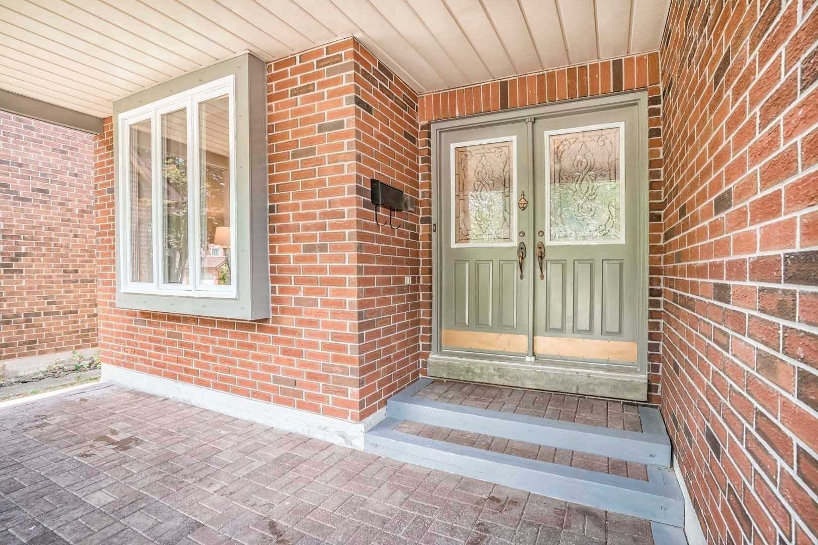 The front entry before the rebuild: brick porch with green double doors
